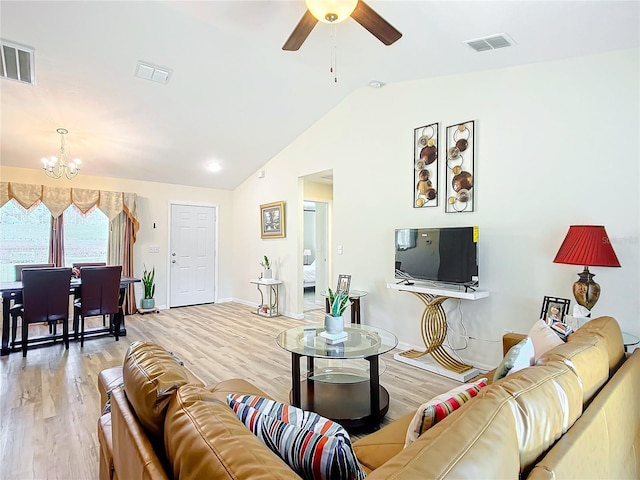 living room with light wood-type flooring, lofted ceiling, and ceiling fan with notable chandelier