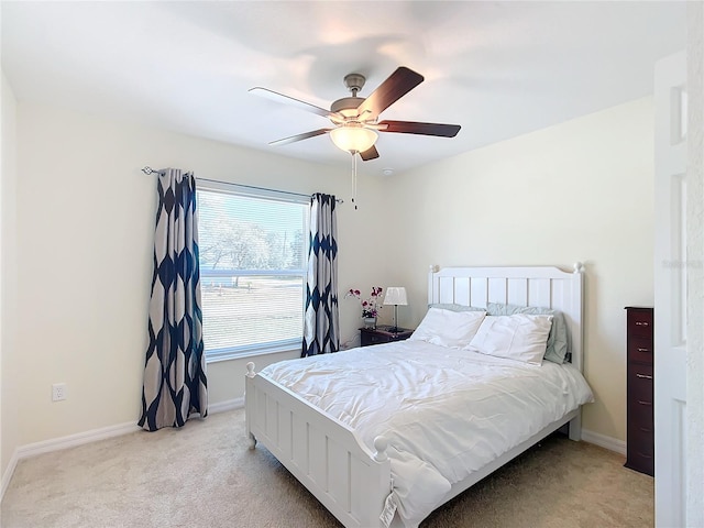 bedroom featuring ceiling fan, light carpet, and multiple windows