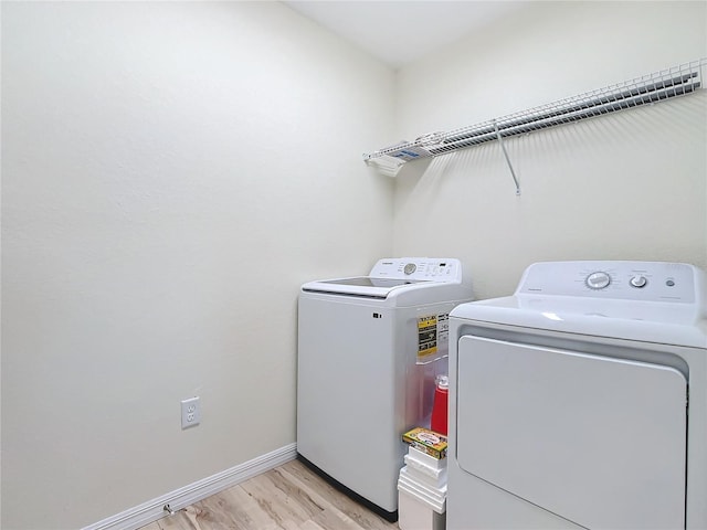 washroom with washer and dryer and light hardwood / wood-style floors