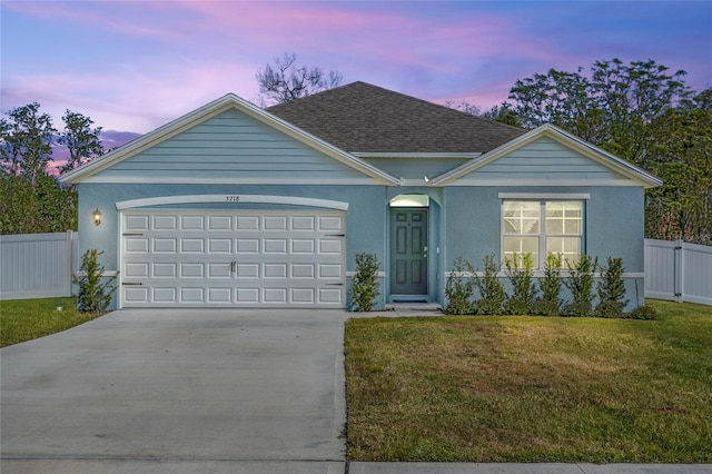 ranch-style house featuring a yard and a garage