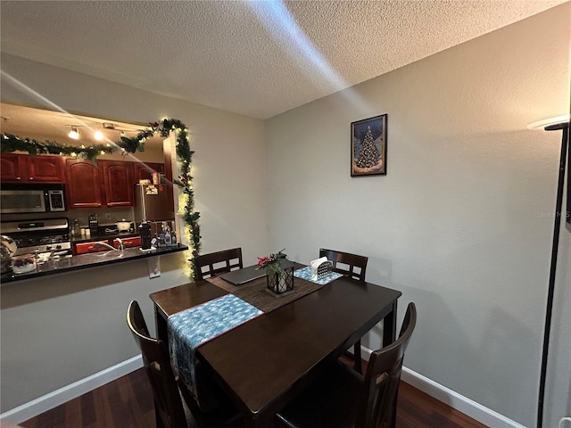 dining area with a textured ceiling and dark hardwood / wood-style floors