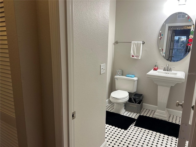 bathroom featuring toilet and tile patterned floors