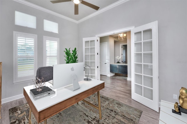 office with crown molding, french doors, ceiling fan with notable chandelier, and hardwood / wood-style flooring