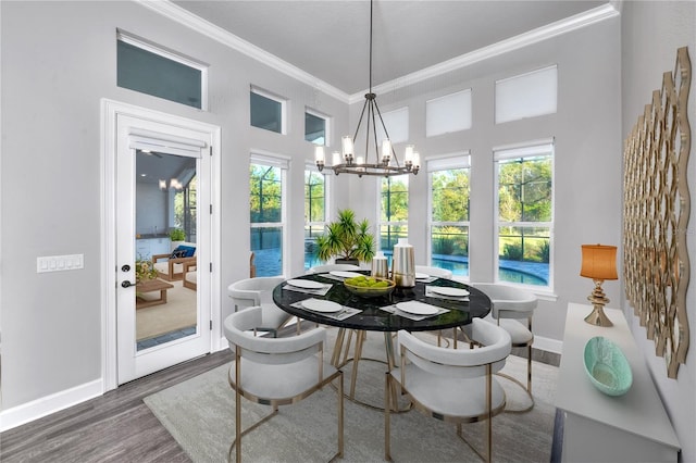 dining space featuring a chandelier, crown molding, and dark wood-type flooring