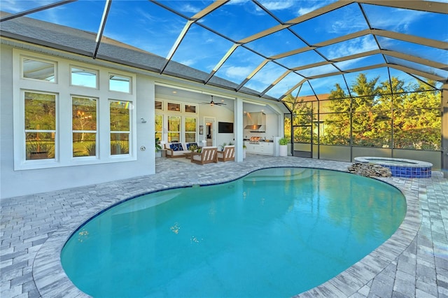 view of pool featuring glass enclosure, ceiling fan, an outdoor hangout area, an in ground hot tub, and a patio