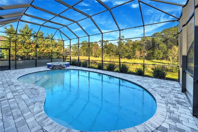 view of swimming pool with glass enclosure, an in ground hot tub, and a patio