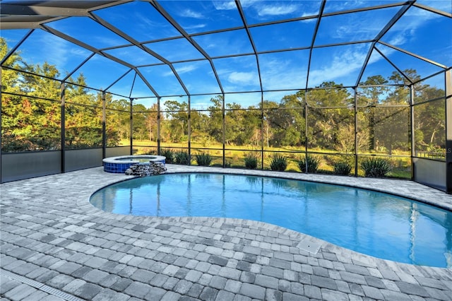 view of pool with a patio area, a lanai, and an in ground hot tub