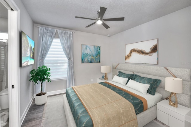 bedroom with a textured ceiling, ceiling fan, and dark wood-type flooring