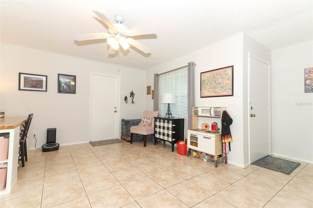 living area with ceiling fan and light tile patterned flooring