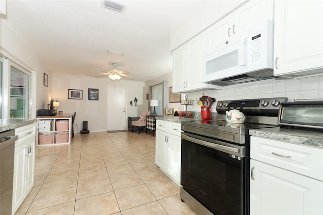 kitchen with white cabinets, ceiling fan, light tile patterned floors, and appliances with stainless steel finishes