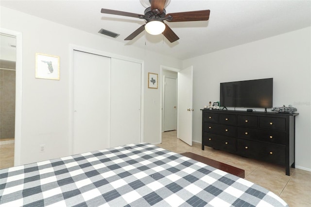 bedroom featuring ceiling fan, a closet, and light tile patterned floors