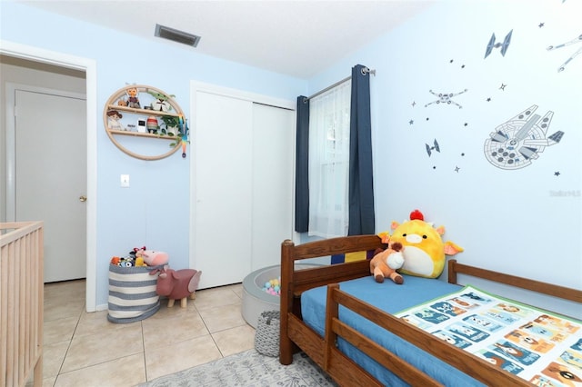 bedroom featuring light tile patterned floors and a closet