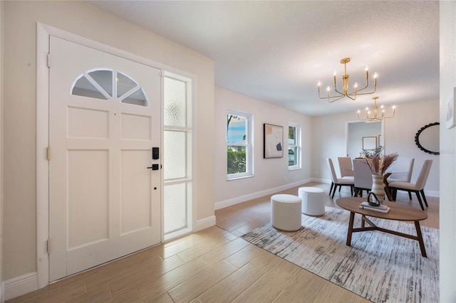 foyer entrance with hardwood / wood-style floors and a notable chandelier