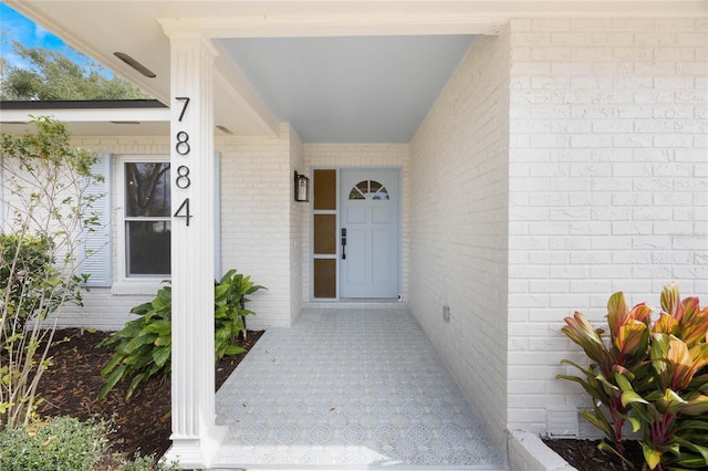 view of exterior entry with brick siding