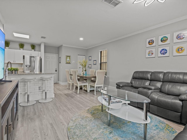 living room with crown molding and light wood-type flooring