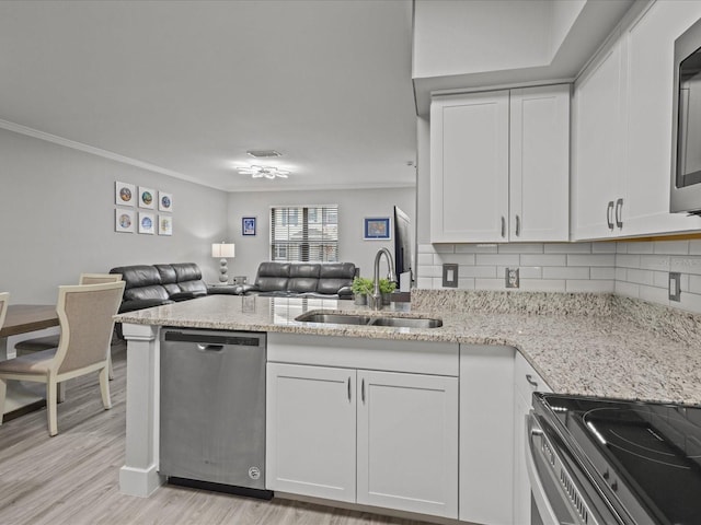 kitchen with white cabinets, backsplash, appliances with stainless steel finishes, and sink