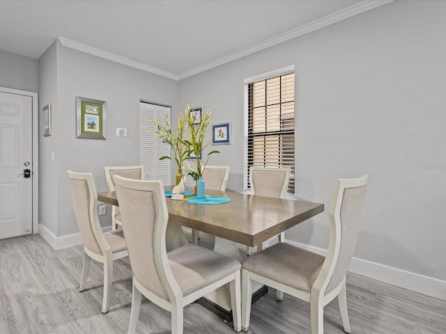 dining space with light hardwood / wood-style flooring and ornamental molding