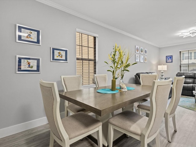 dining space featuring hardwood / wood-style floors and crown molding