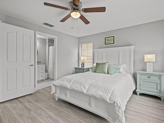 bedroom featuring ceiling fan, ensuite bathroom, and light hardwood / wood-style flooring