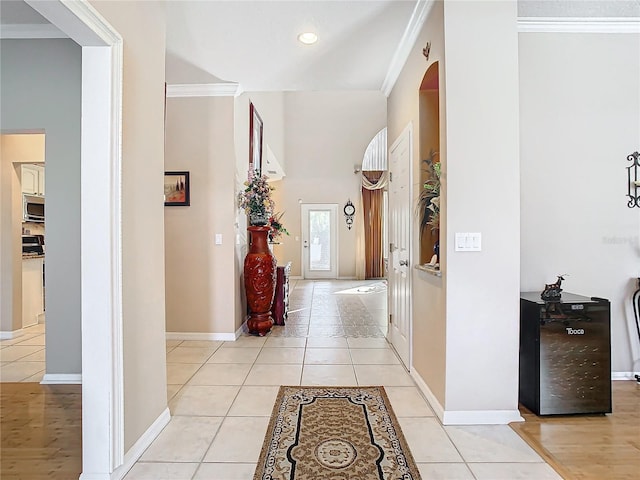 hallway featuring light tile patterned floors and crown molding