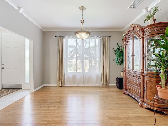 entryway featuring light hardwood / wood-style floors and crown molding