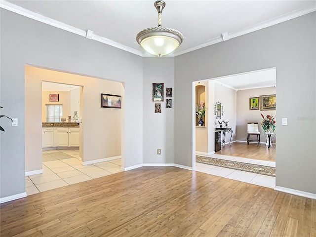 unfurnished room with light hardwood / wood-style floors and crown molding