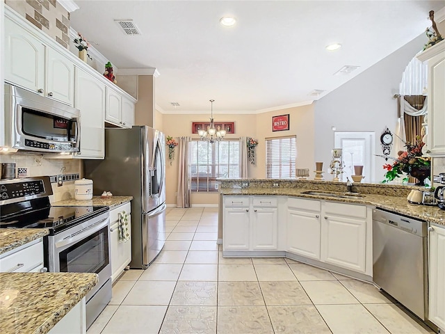 kitchen featuring white cabinets, an inviting chandelier, appliances with stainless steel finishes, and sink