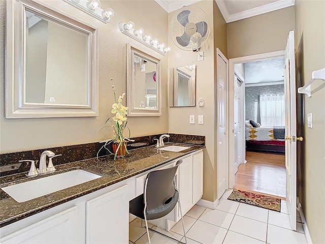 bathroom with tile patterned flooring, ornamental molding, and vanity