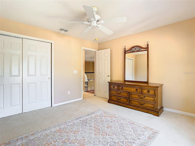 carpeted bedroom featuring ceiling fan and a closet