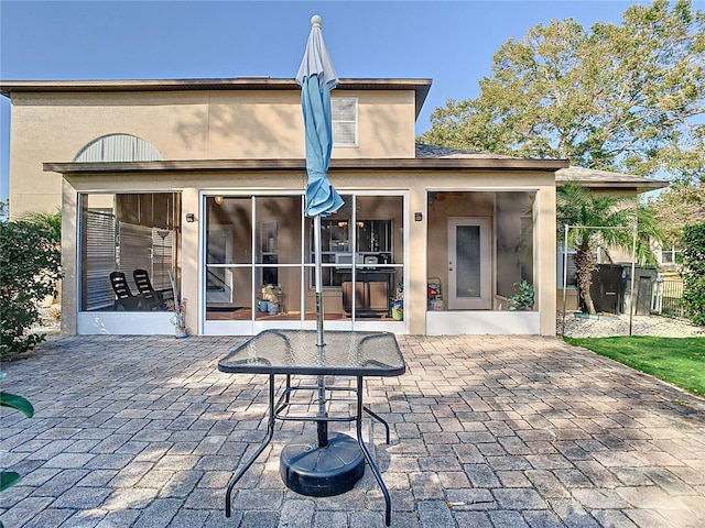 rear view of house with a patio and a sunroom