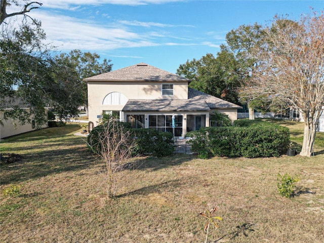 view of front of home featuring a sunroom and a front lawn