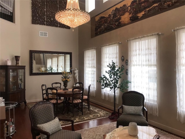 living room with a towering ceiling, hardwood / wood-style flooring, and a notable chandelier