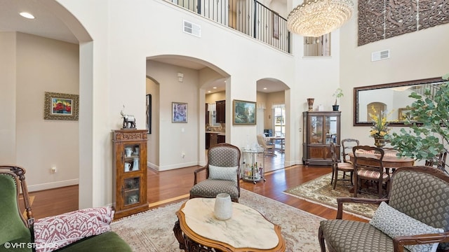 living room featuring a high ceiling, dark hardwood / wood-style floors, and a notable chandelier