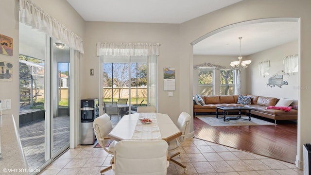 dining space featuring light tile patterned flooring and an inviting chandelier