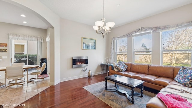 living room with hardwood / wood-style floors, a notable chandelier, and plenty of natural light