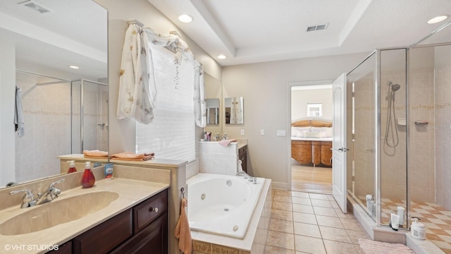 bathroom featuring independent shower and bath, vanity, tile patterned floors, and a tray ceiling