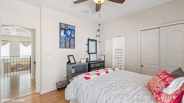 bedroom featuring hardwood / wood-style flooring, ceiling fan, and a closet