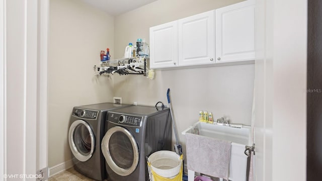 laundry room featuring cabinets, sink, and washing machine and clothes dryer