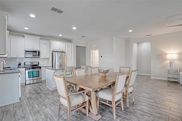 dining area with sink and light hardwood / wood-style flooring