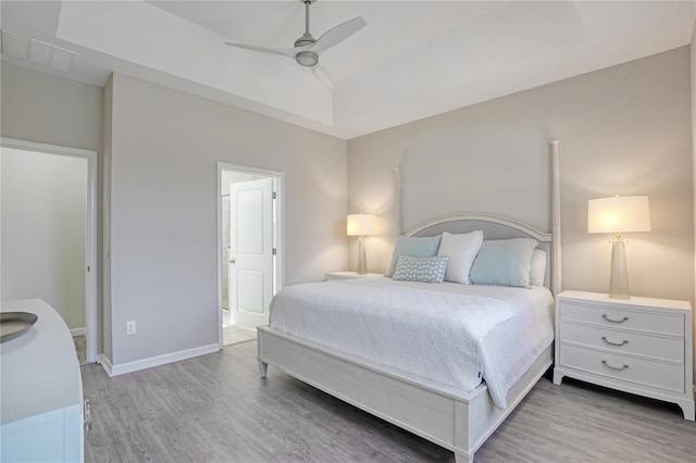 bedroom featuring ceiling fan, light wood-type flooring, and vaulted ceiling