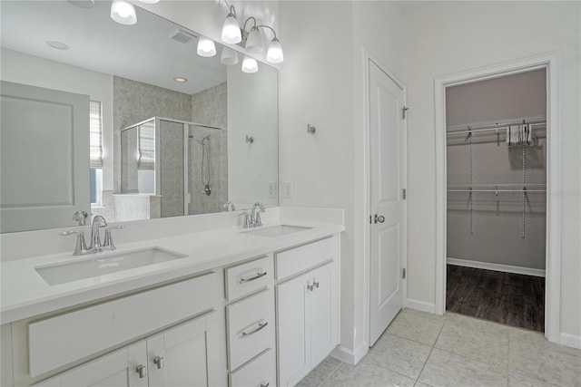 bathroom featuring tile patterned floors, a shower with door, and vanity