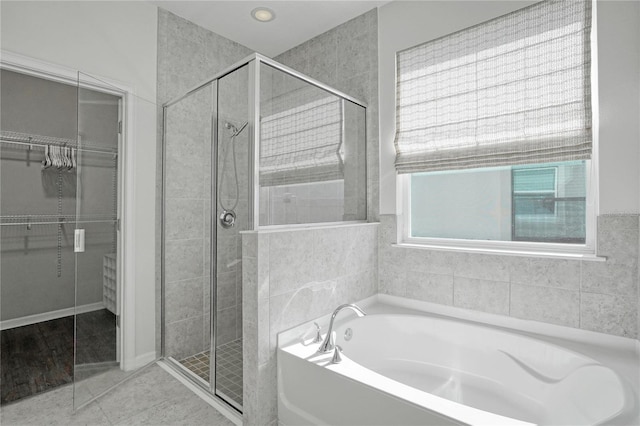 bathroom with tile patterned floors and independent shower and bath