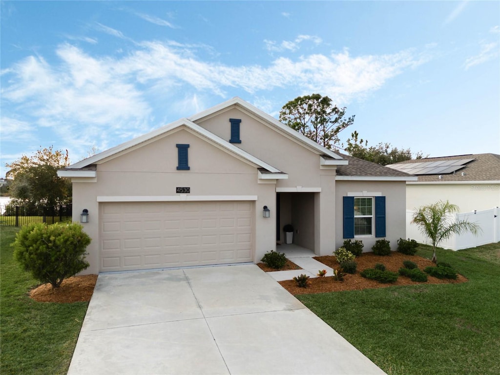 ranch-style home with driveway, an attached garage, fence, a front lawn, and stucco siding