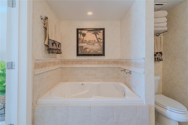 bathroom featuring tiled bath and toilet