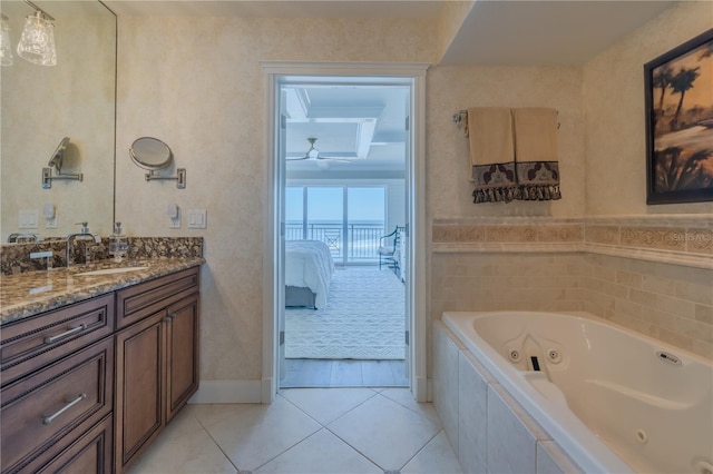 bathroom featuring tile patterned flooring, vanity, and tiled tub