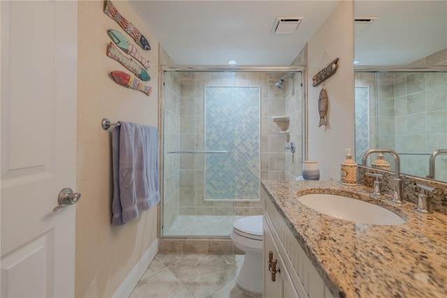 bathroom featuring tile patterned flooring, toilet, vanity, and walk in shower