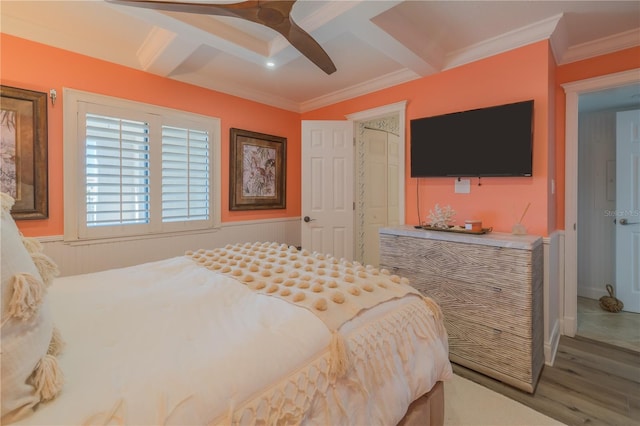 bedroom with ceiling fan, wood-type flooring, ornamental molding, and coffered ceiling