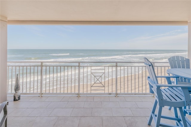 balcony featuring a beach view and a water view