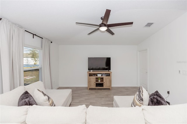 living room with ceiling fan and light wood-type flooring