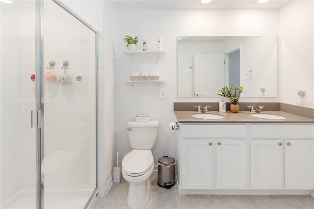 bathroom with tile patterned flooring, vanity, toilet, and an enclosed shower